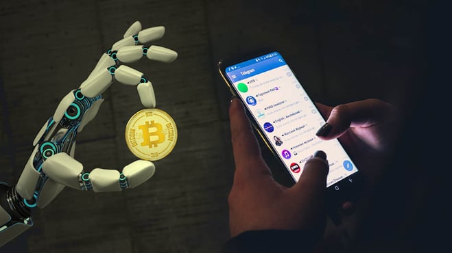روبوت يمسك عملة بيتكوين بجوار تطبيق تيليجرام